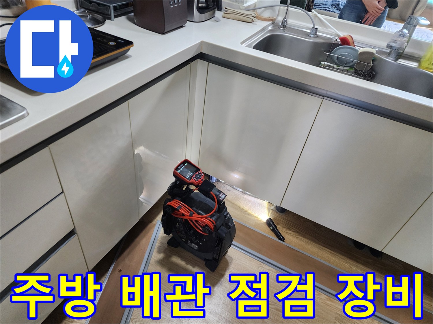 싱크대 하부장 아래 배치된 배관 내시경 카메라와 탐지용 장비
