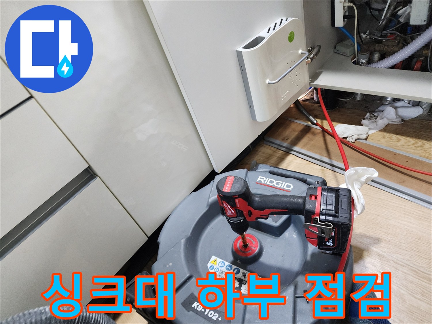 좁은 주방 하부 공간에 설치된 배관 점검용 내시경과 드릴