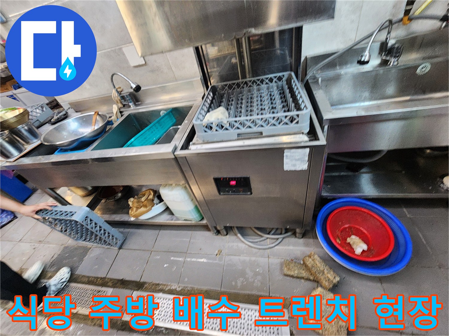 상업용 식당 주방의 스테인리스 싱크대와 바닥 배수 트렌치 주변 모습
