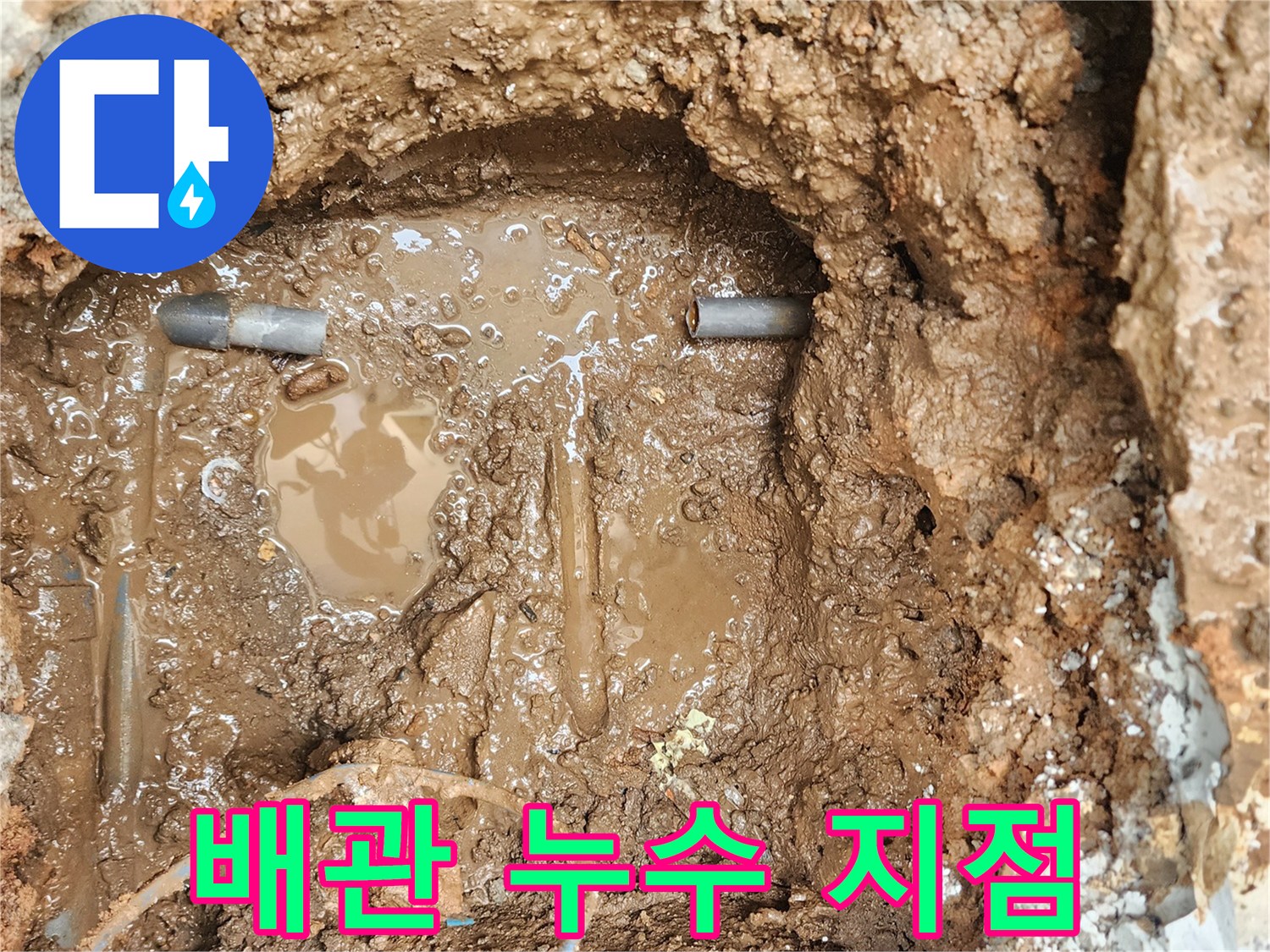 물에 젖은 토양과 함께 드러난 파손된 배관의 연결부