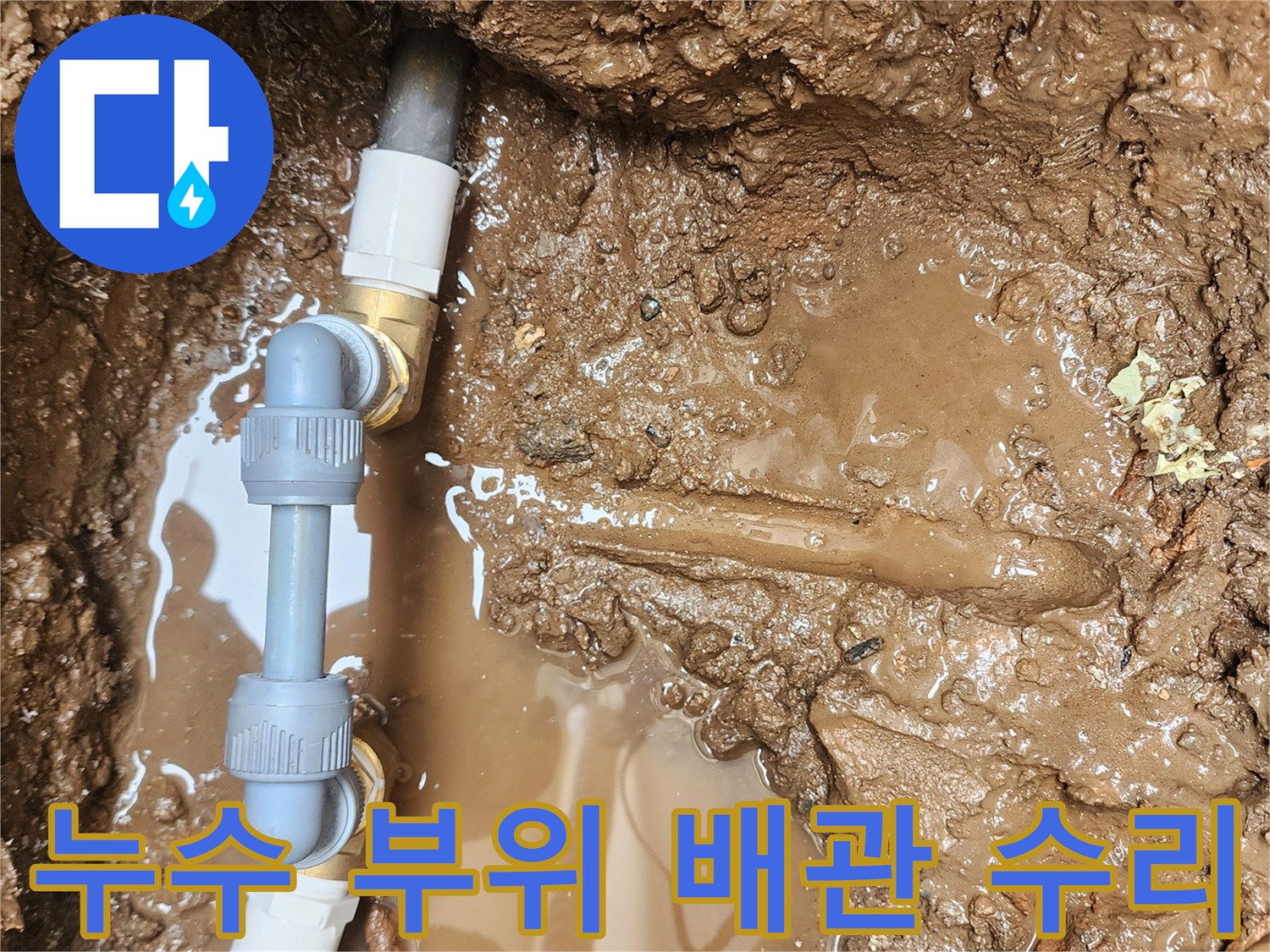 진흙이 고인 굴착 지점-파손된 배관과 교체용 소켓 작업 현장