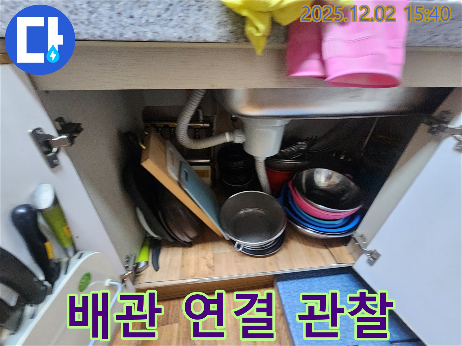 포천시 일동면 길명리에서 싱크대 배관 연결 부위를 집중적으로 관찰하고 있습니다 - 작은 틈새나 물방울을 찾아 누수 여부를 판단합니다.