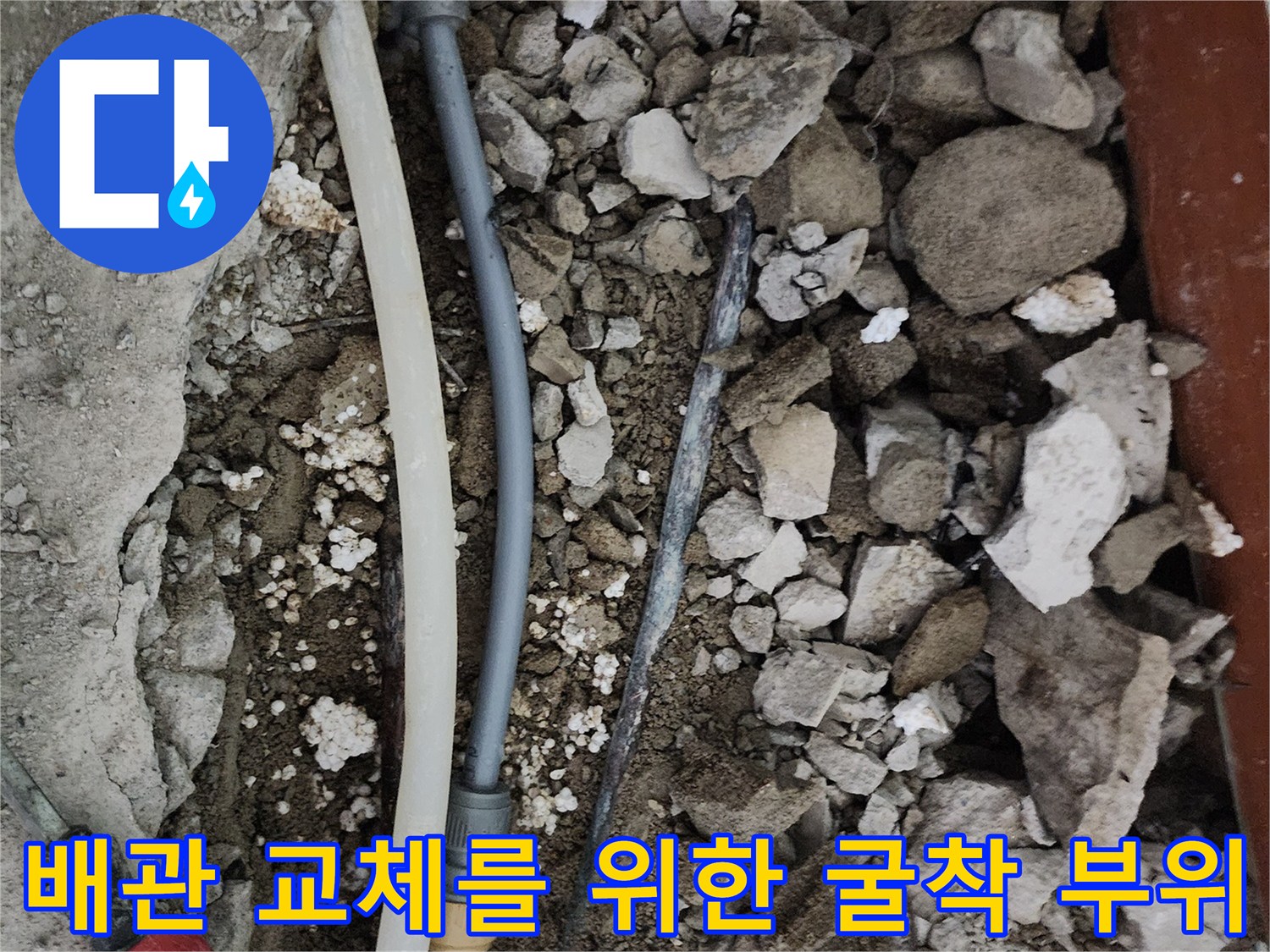 누수 지점의-파손된 배관과 주변 흙 및 공구 모습