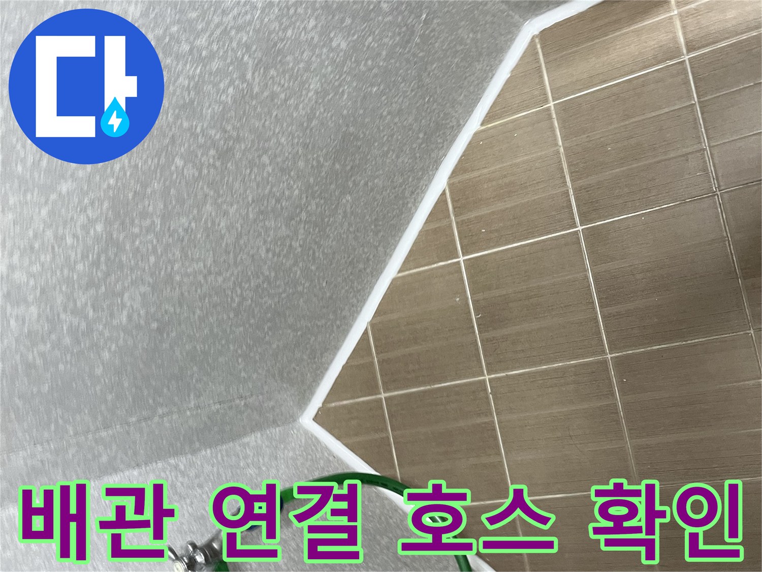 벽면에 고정된 수전과 연결된 초록색 호스의 모습