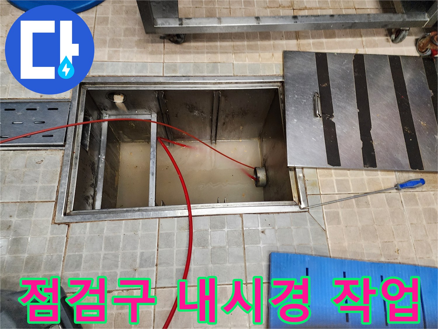 금속-재질의 점검구 덮개와 내부로 들어간 내시경 장비