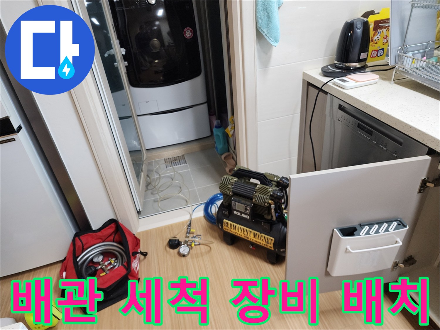싱크대 하부 작업 공간에 놓인 배관 청소용 컴프레셔와 공구 가방