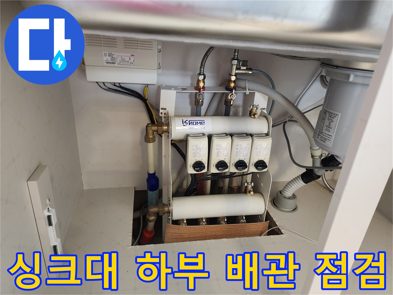 싱크대 아래 분배기와 연결된 금속 및 플라스틱 배관