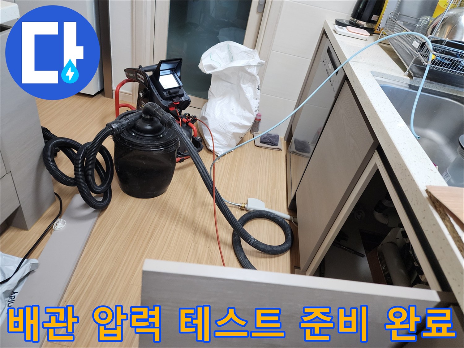 싱크대 하단 배관 연결 부위에 압력 측정용 호스가 설치된 모습입니다.