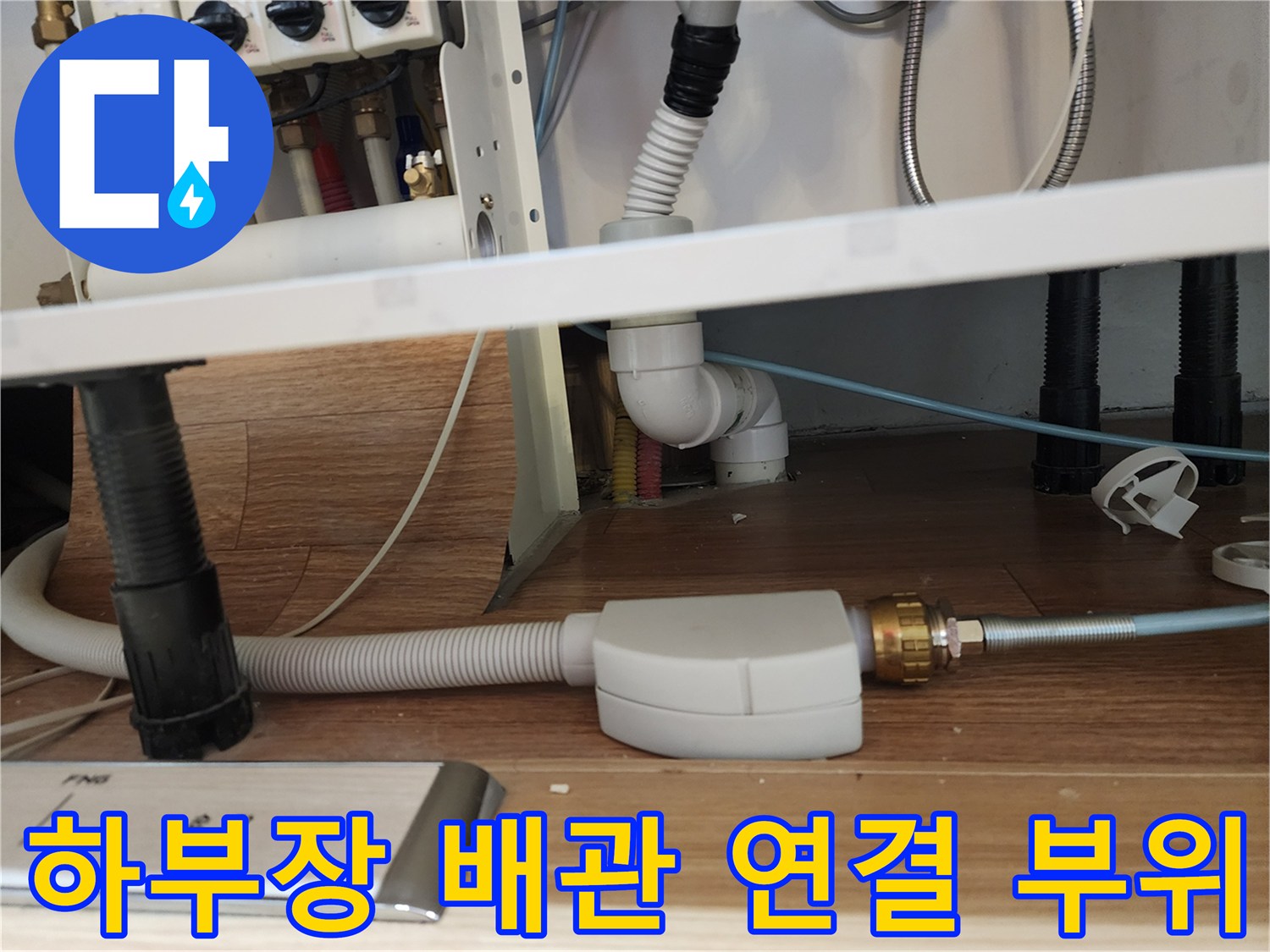 싱크대 하단에 복잡하게 얽힌 급수 및 배수 배관 구조