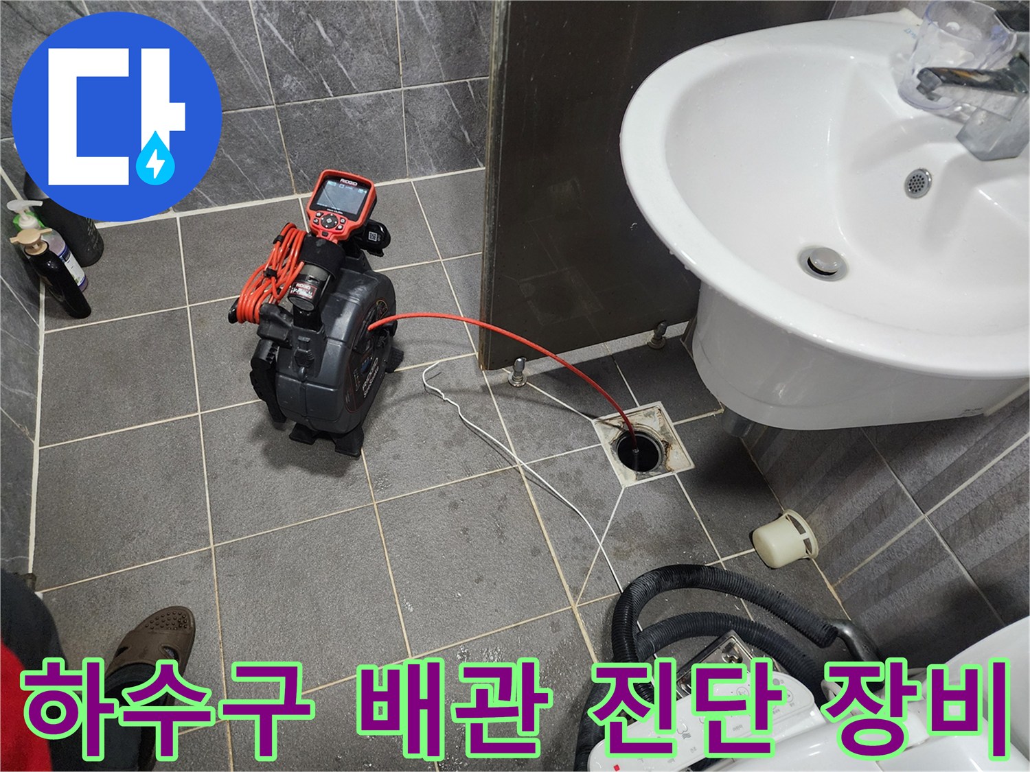 디지털 압력계와 배관 연결 호스가 놓인 화장실 바층 모습