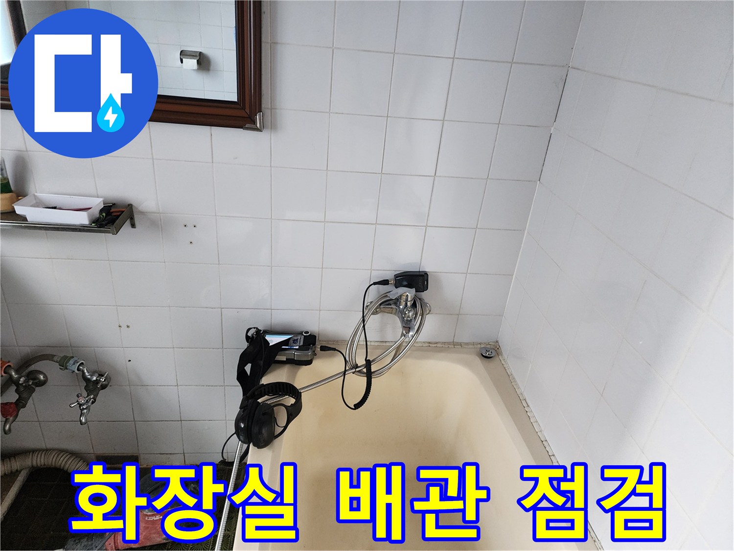 욕조 옆 타일 벽면에 설치된 가스 탐지용 호스와 수압 측정 장비입니다.