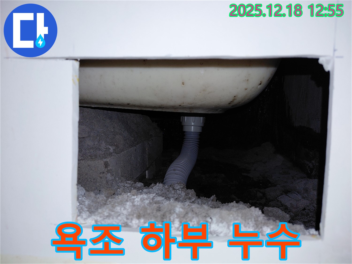 욕조 하부 배관에서 누수가 발생하여 주변에 물이 고여있는 모습입니다 - 빠른 누수 탐지와 보수가 필요합니다.