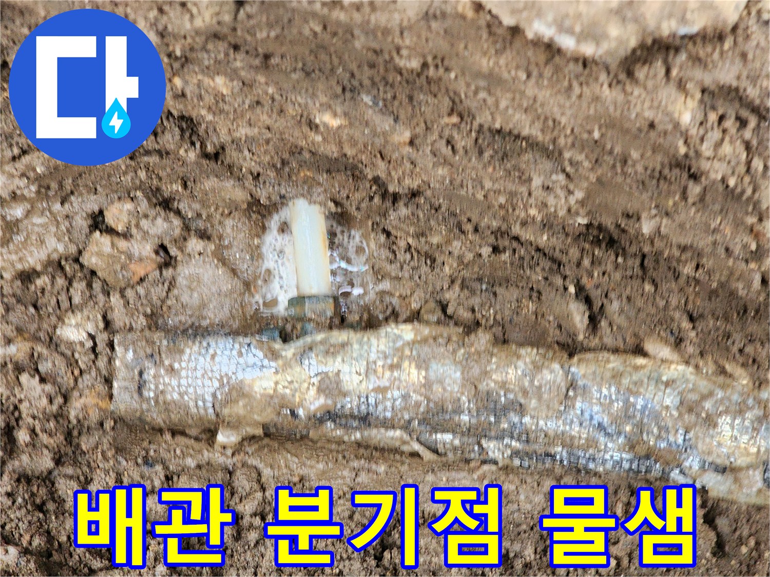 보온재로 감싸진 배관의 연결 부위에서 물이 새어 나오는 모습입니다.