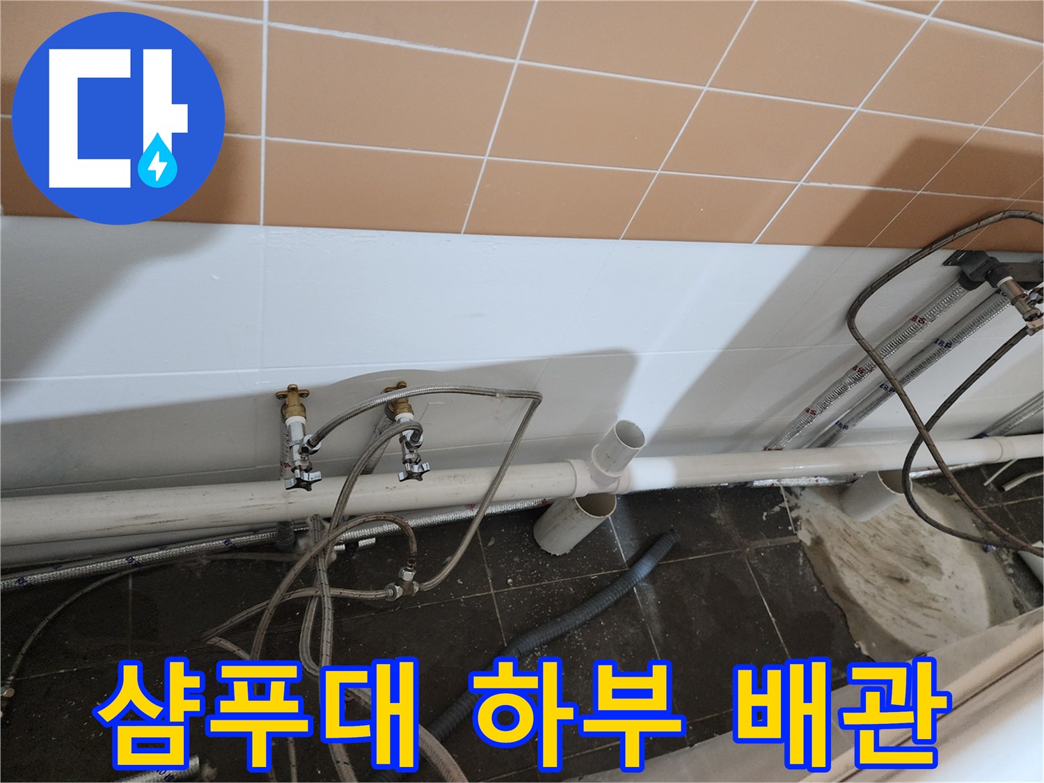 미용실 샴푸대 아래쪽의 노출된 배관과 연결 부위 상태를 촬영한 사진입니다.