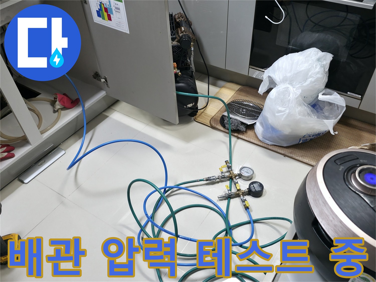싱크대 아래쪽 배관에 연결된 가스 탐지용 호스와 게이지