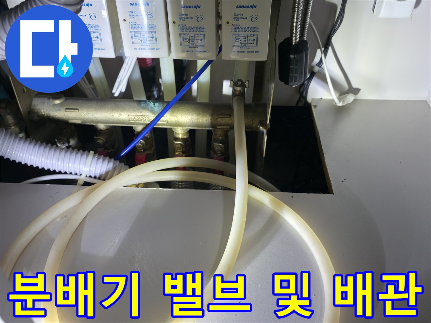 싱크대 하부장에 위치한 수도 분배기 부속품 사진입니다.