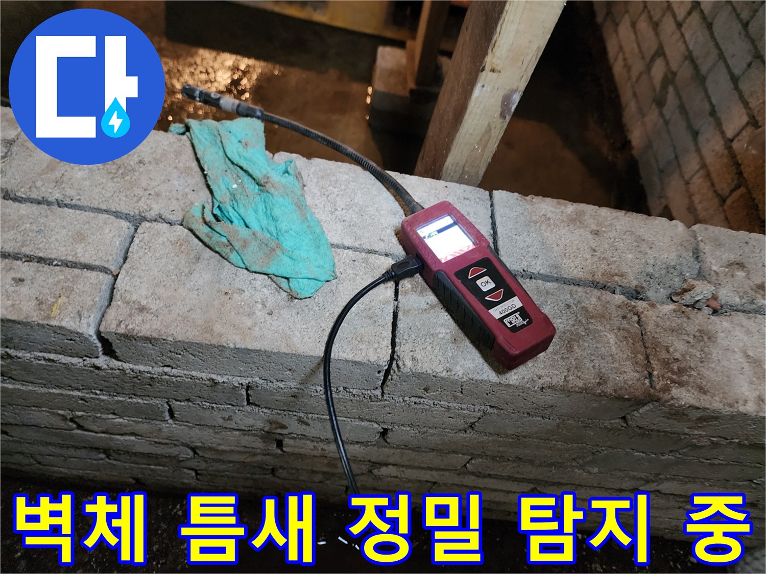 벽면 균열 부위에 연결된 가스 탐지 장비와 검사 호스 상세 모습