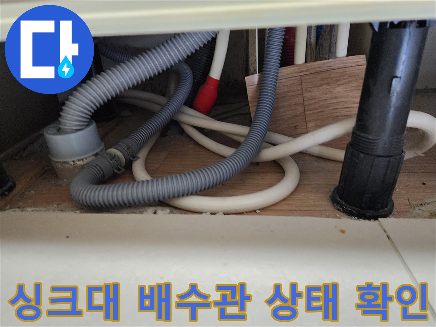 노원구 중계동 주방 싱크대 하부의 복잡한 배수 호스와 배관 연결 부위 모습
