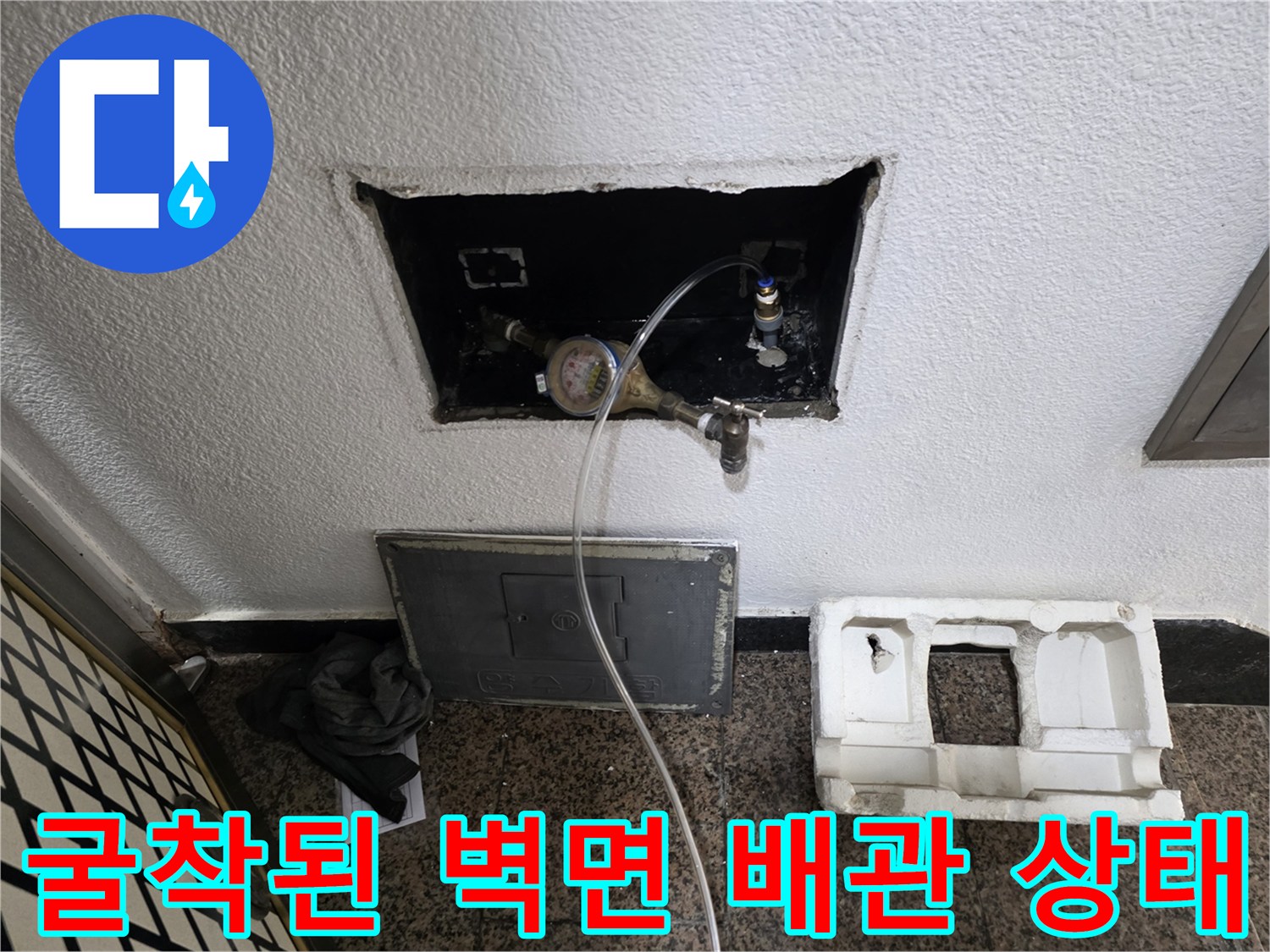 벽면 내부로 노출된 수도 계량기와 연결 밸브의 상세 모습