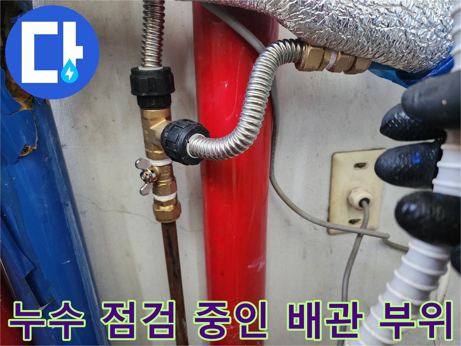 금속 밸브와 은색 호스가 연결된 수도 배관 상세 모습