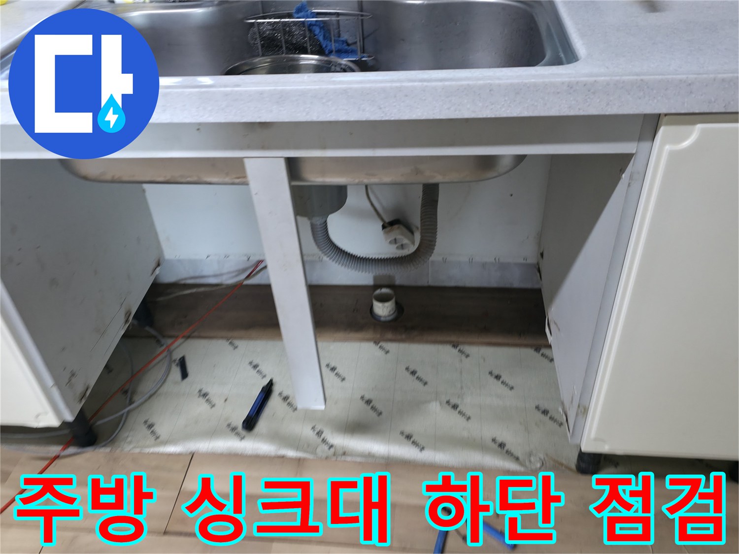 싱크대 내부 배수 호스와 벽면 배관의 연결 상태를 나타냅니다.