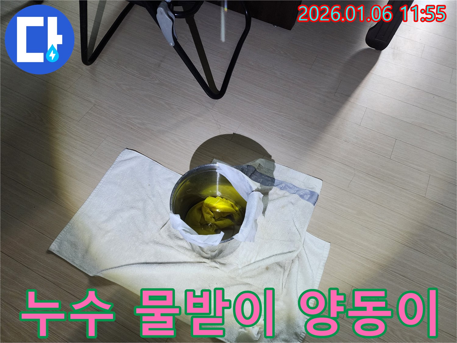 누수 발생 지점 아래에 놓인 물받이 양동이 - 누수로 인한 피해를 최소화하기 위한 임시 조치