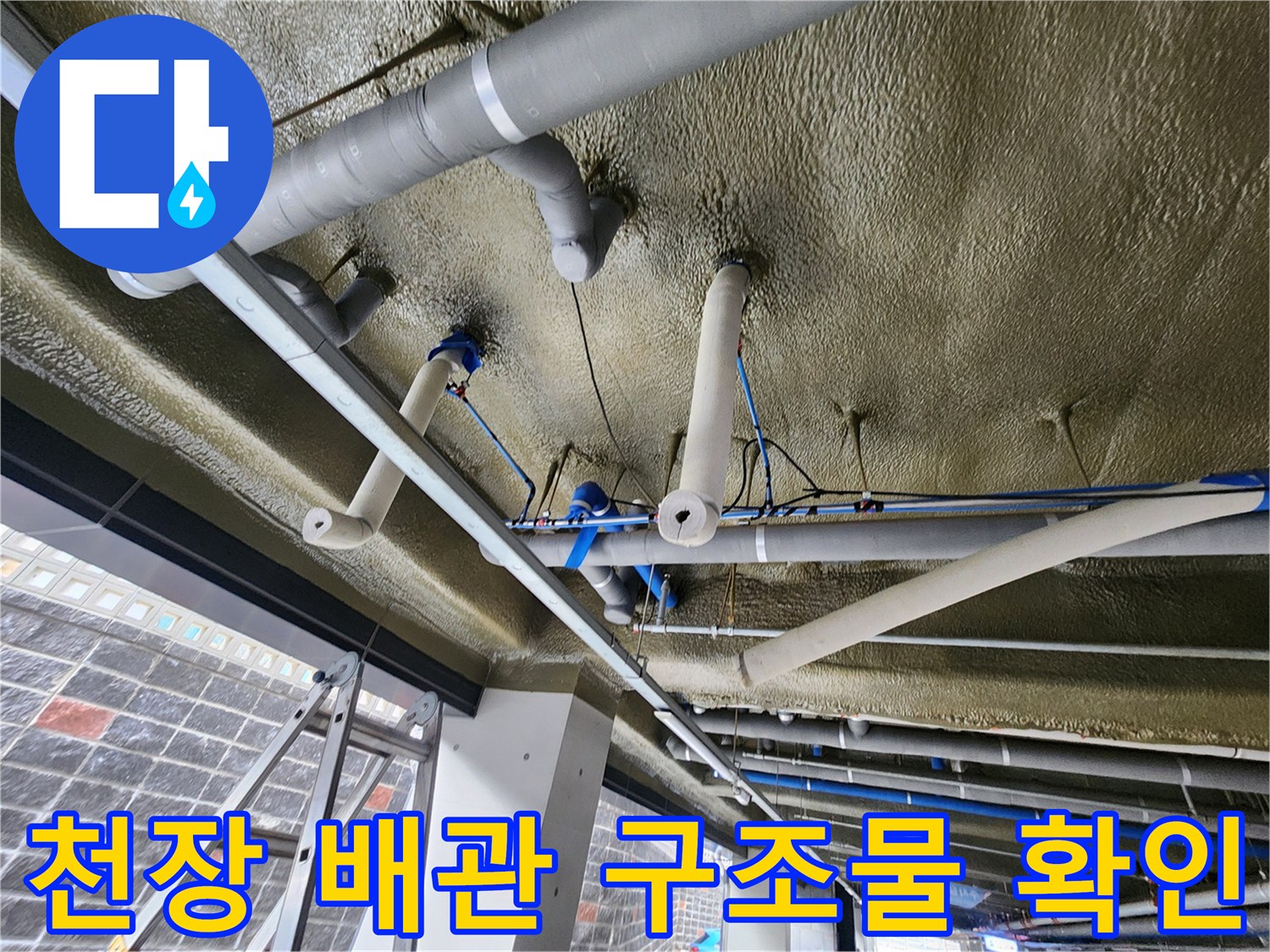 지하주차장 상단에 설치된 다양한 규격의 배관들을 보여주는 사진입니다.