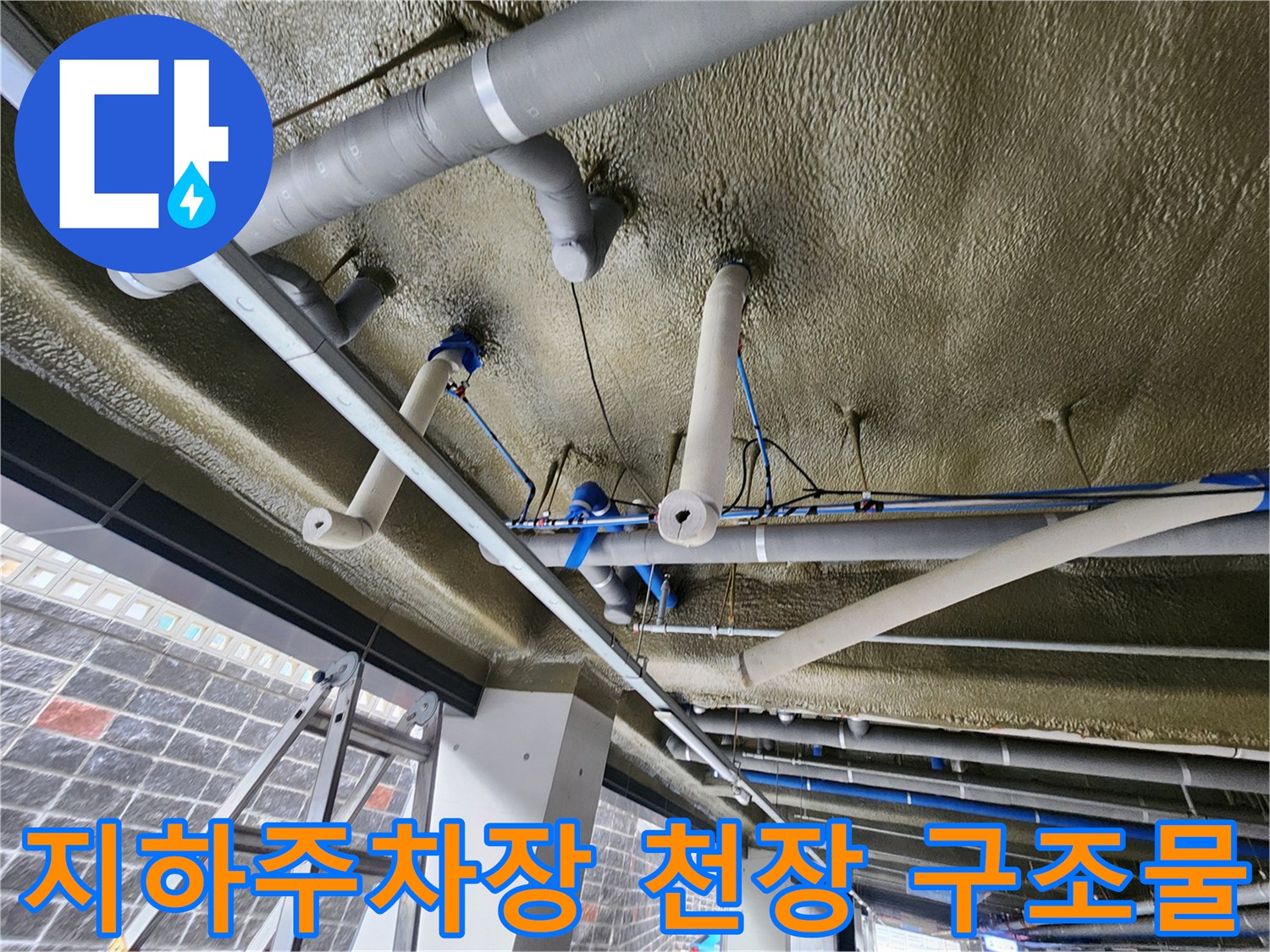 지하주차장 천장에 설치된 다양한 규격의 배관 및 보온재 모습