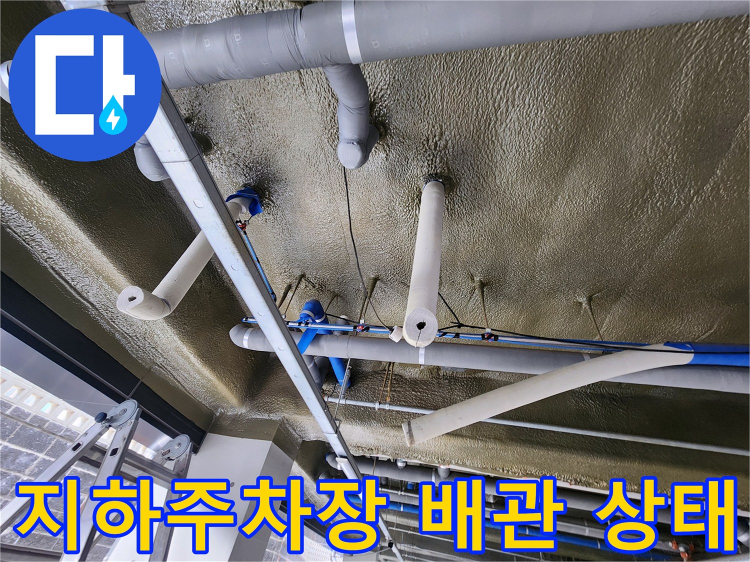 지하주차장 천장에 설치된 보온재 마감된 배관 시스템 모습