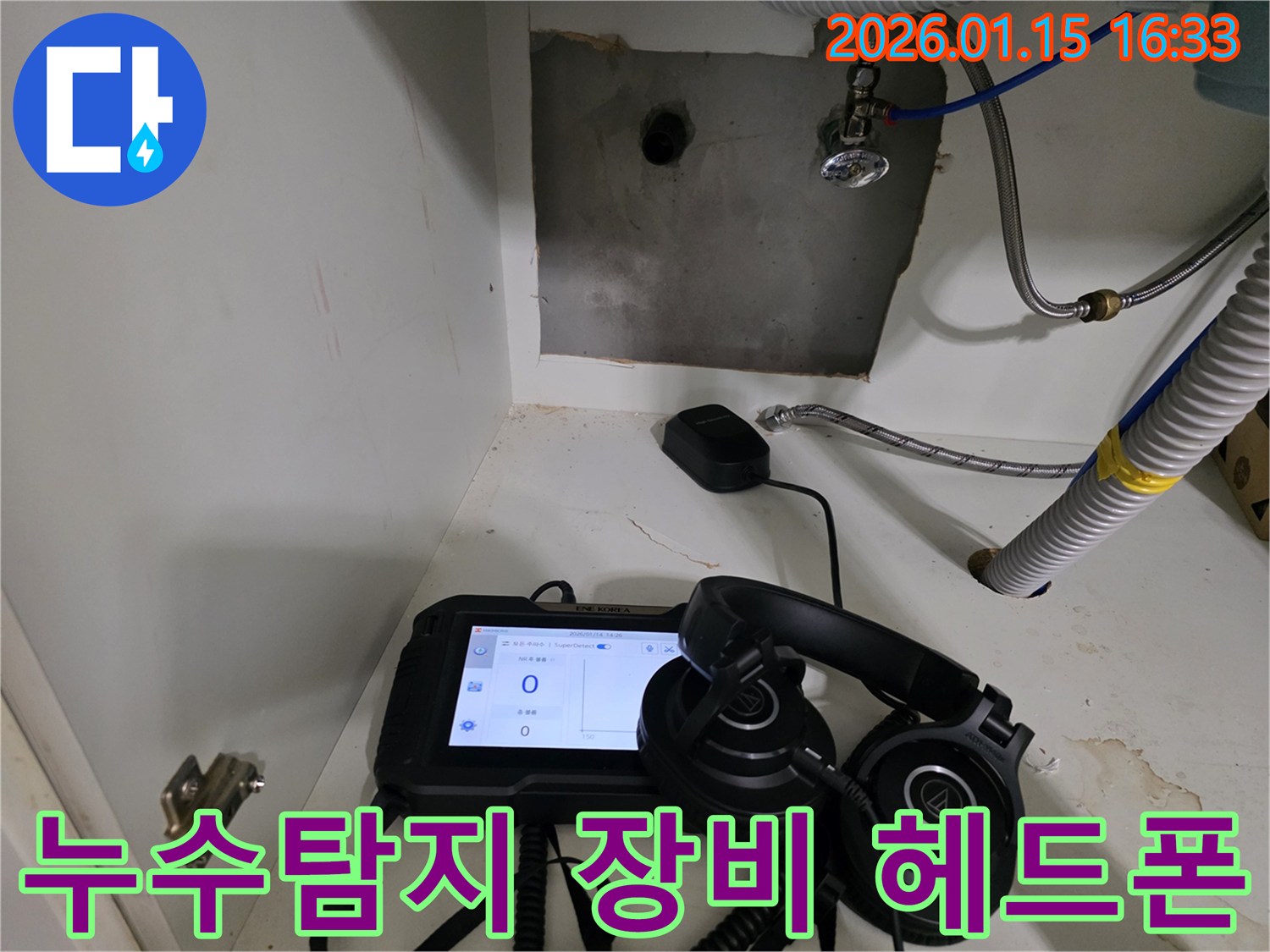 누수음을 정밀하게 듣기 위해 헤드폰과 탐지 장비를 사용하고 있습니다.