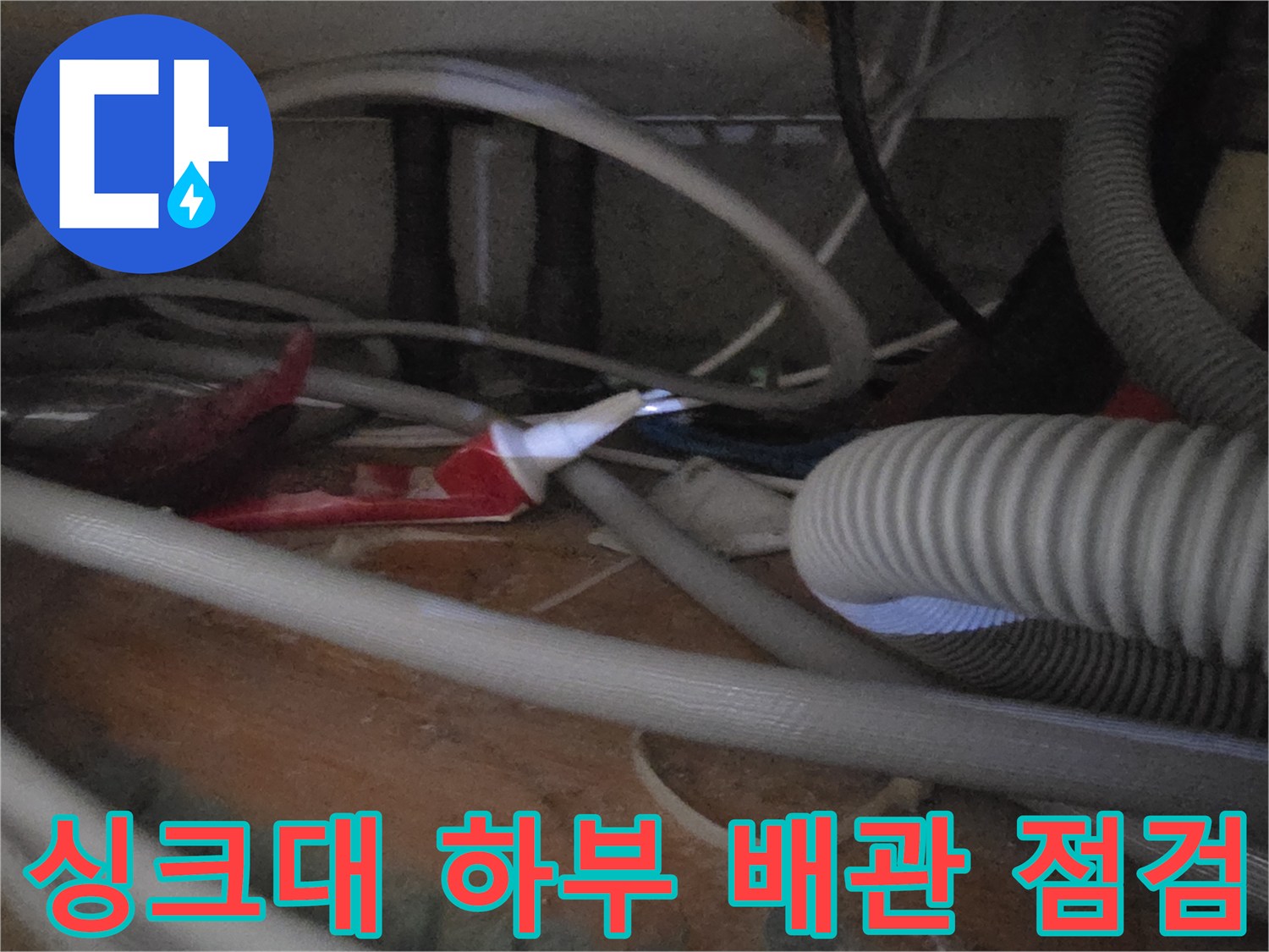 싱크대 아래쪽 주름관과 여러 가닥의 급수 호스 배열 상태