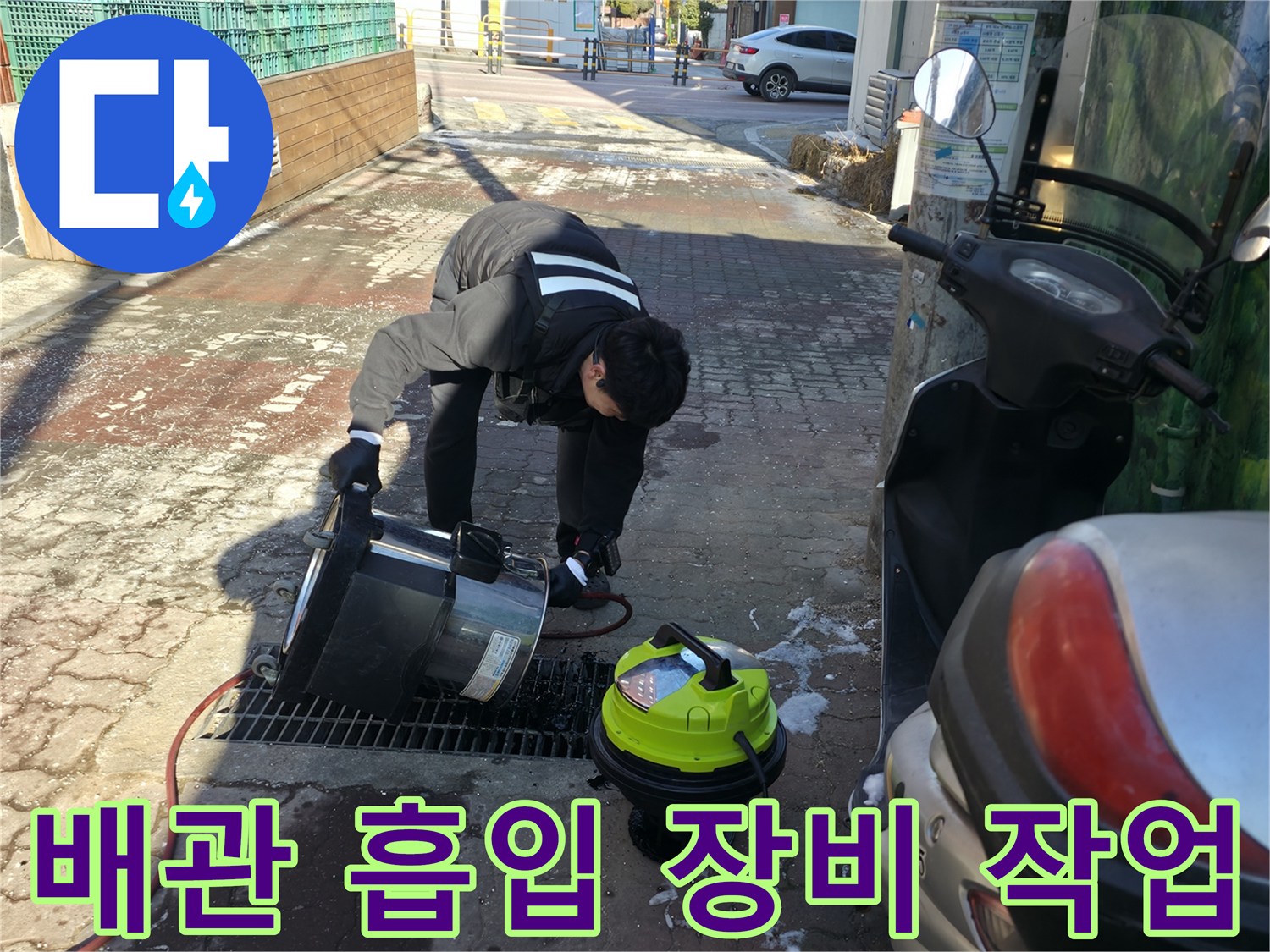 하수 배관 내부의 이물질을 제거하기 위해 강력한 흡입기를 사용하는 모습입니다.