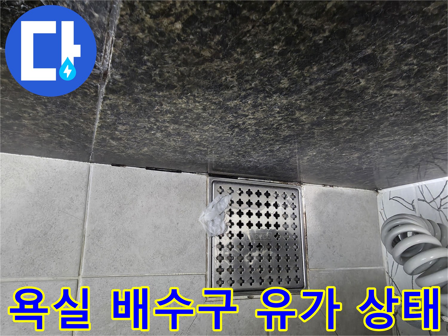 화장실 바닥 타일과 금속 배수구 유가의 접합 부위 상세 사진