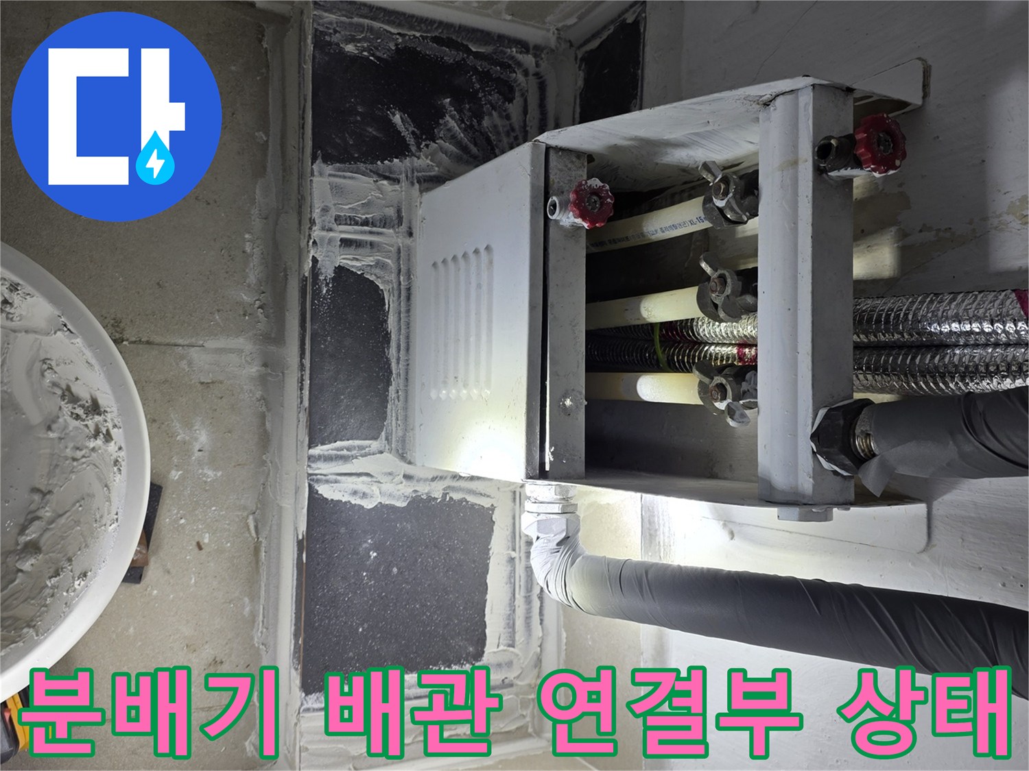 분배기-하단의-연결-부속과-배관을-근접 촬영한-사진