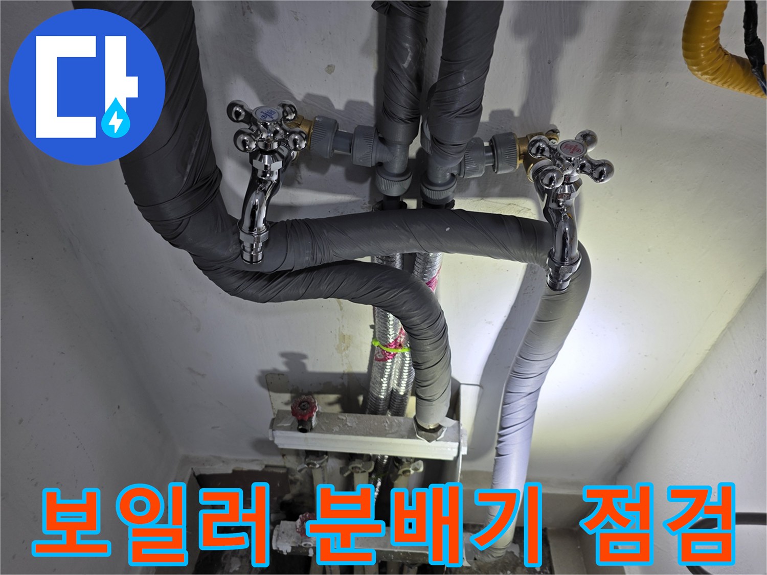 분배기와-보온재가-씌워진-배관의-접합부를-살피는-모습