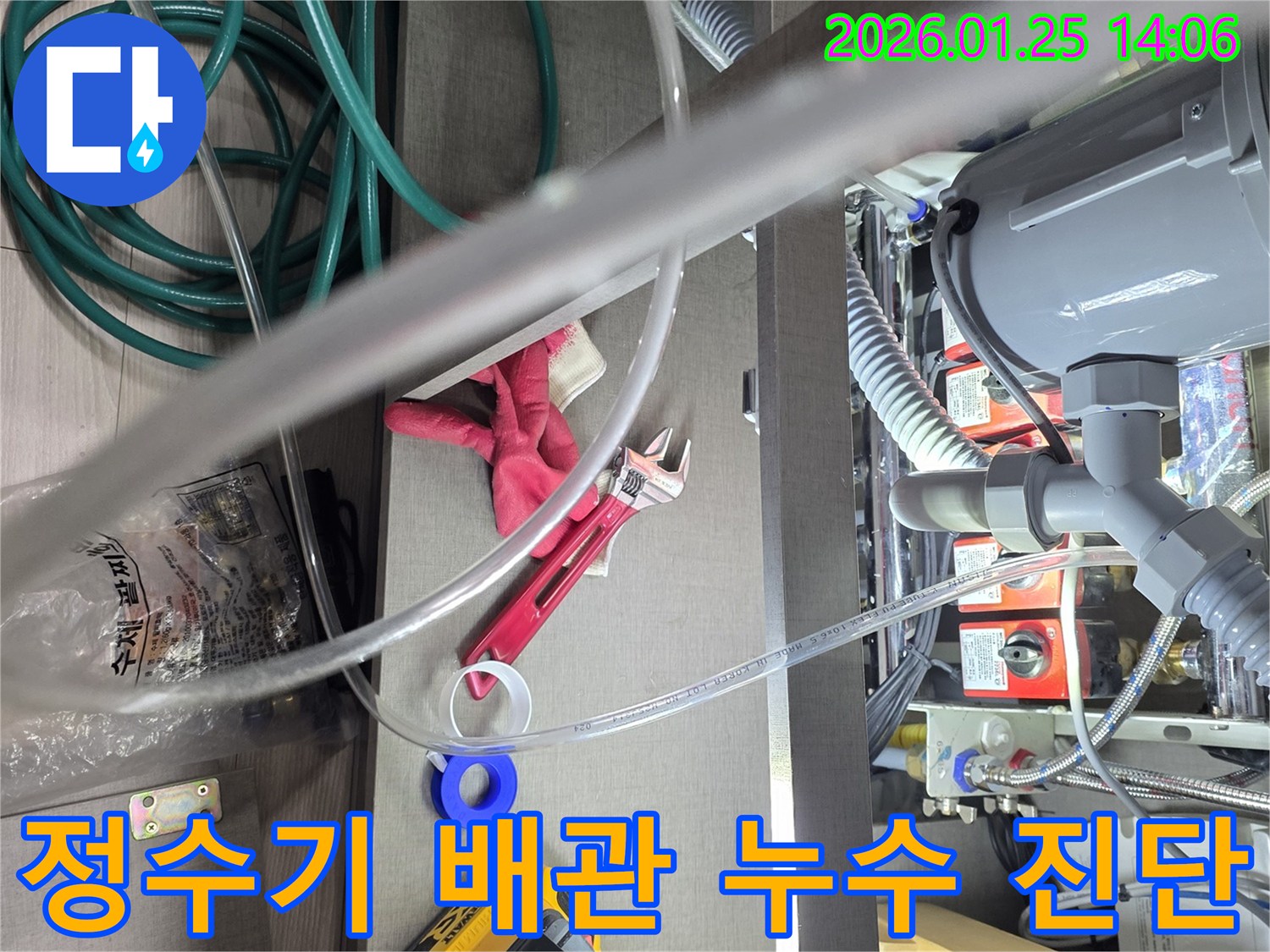 이 이미지는-정수기 또는-유사한 가전제품의-연결부위에서 발생한-누수를 진단하기 위해-사용된-전문 공구와-배관의 모습을-보여줍니다.