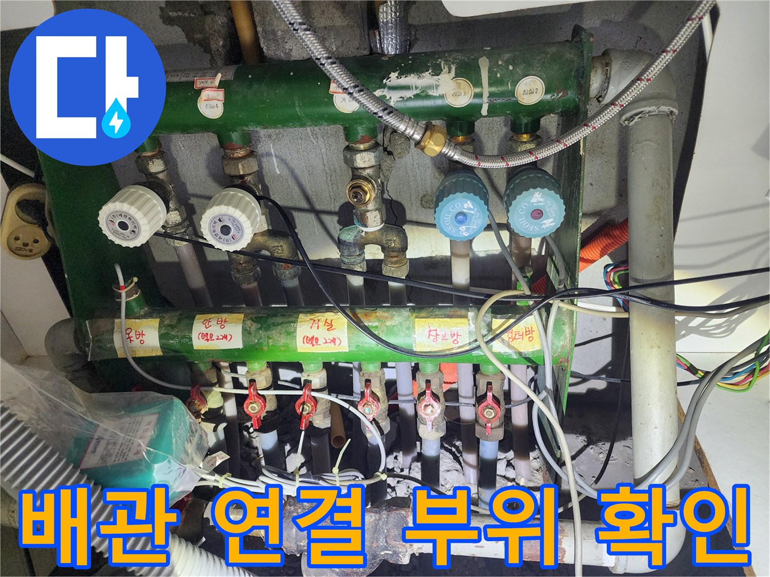 싱크대 하부 녹색 분배기와 밸브들의 복합적인 연결 구조