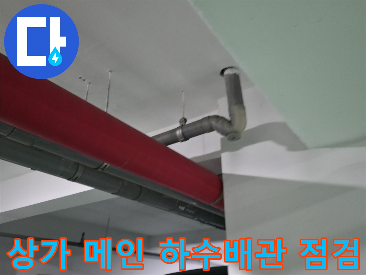 상가 내부의 붉은색 외벽과 연결된 회색 배관 구조물