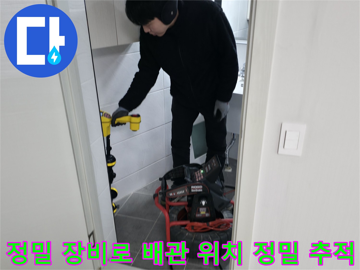 화장실 바닥면 아래 숨겨진 하수 및 오수 라인을 전용 장비로 탐지하는 기술자의 모습