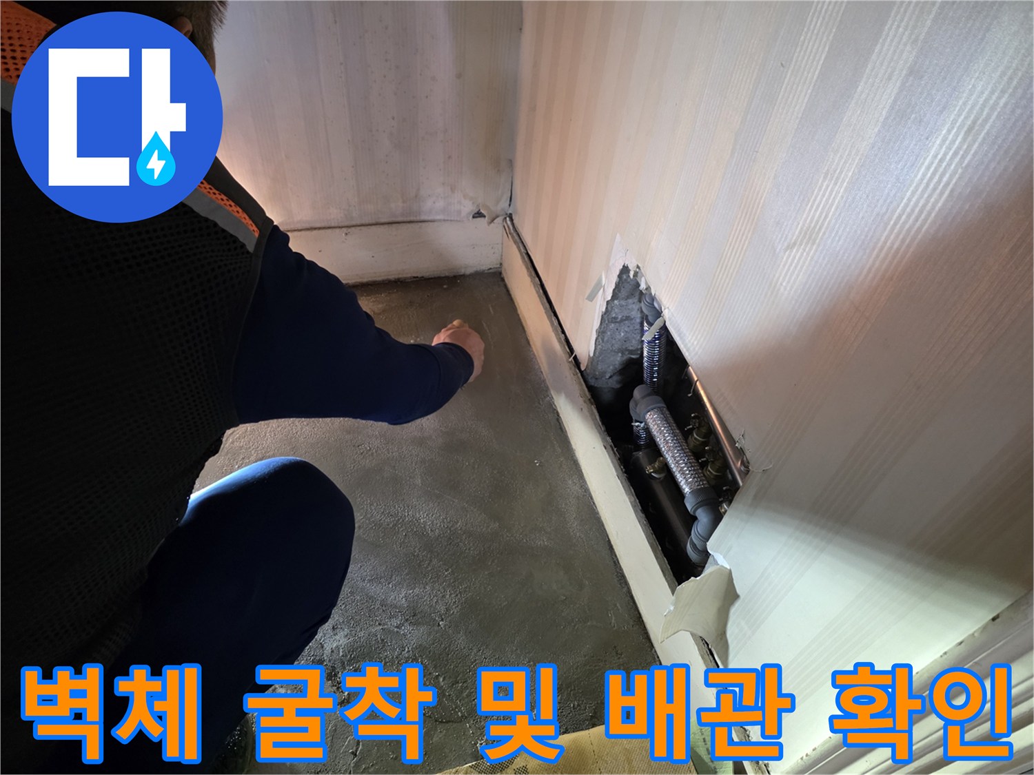 벽면을 파낸 뒤 드러난 은색 배관과 금속 부속의 상태입니다.
