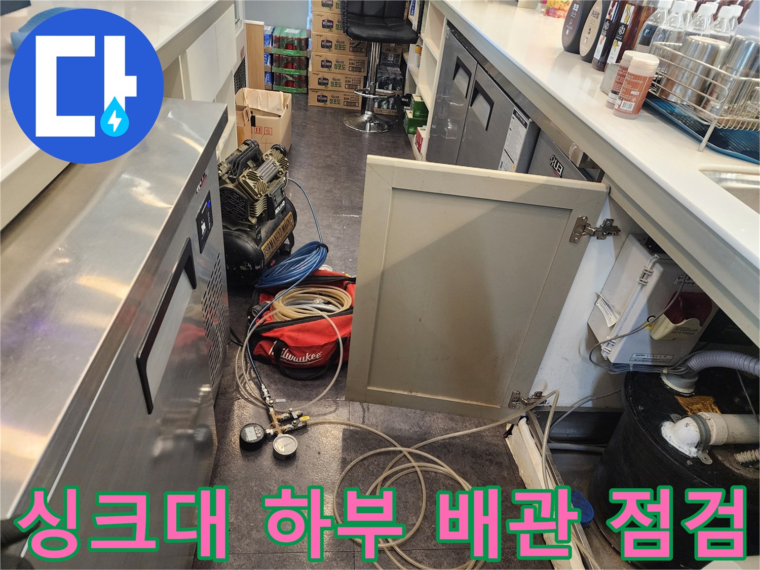 서초구 상업용 주방 싱크대 아래쪽 복잡한 배관과 누수 탐지 장비 모습