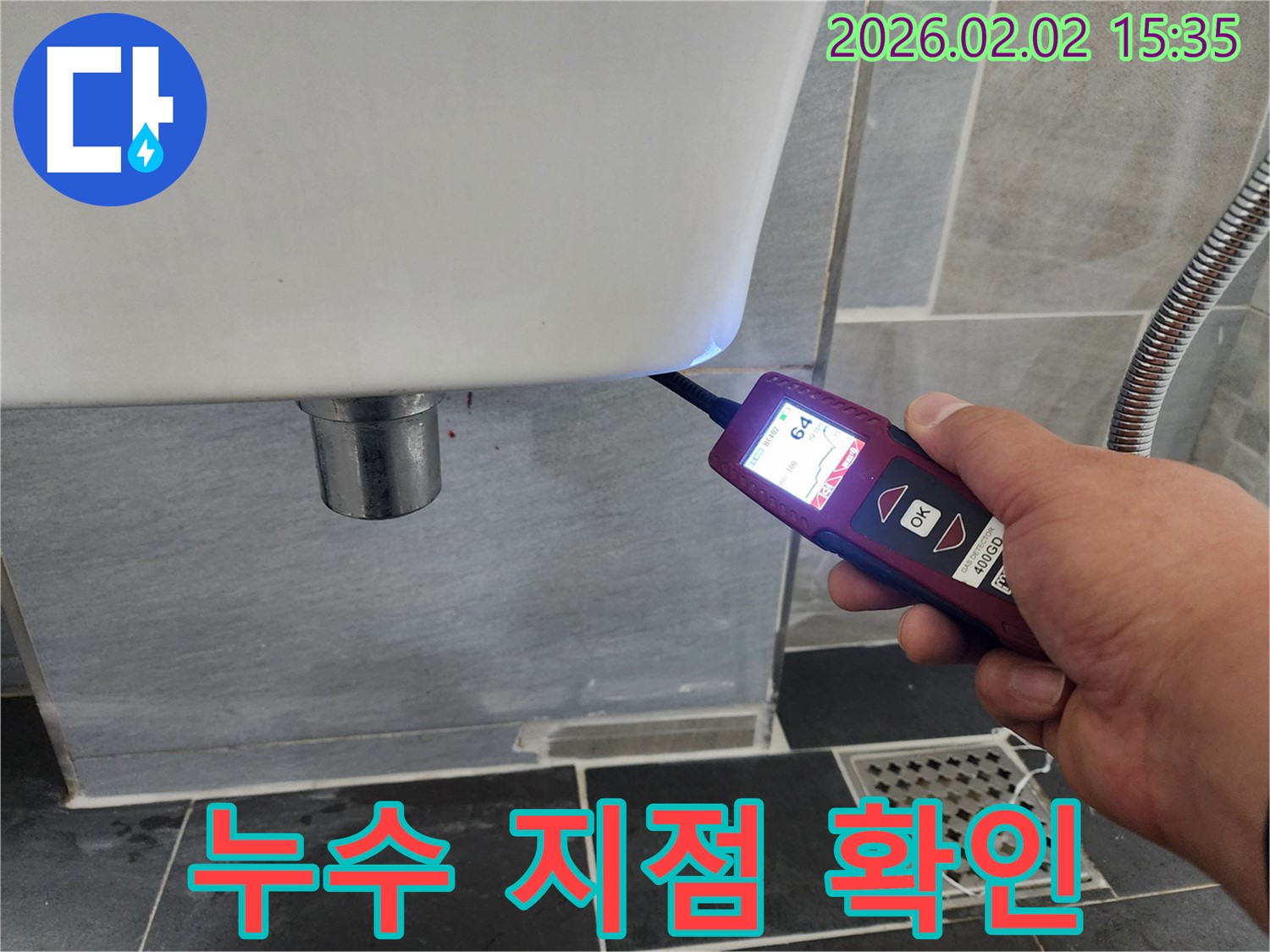 누수 지점 확인 - 누수 탐지 장비를 사용하여 세면대 누수의 정확한 지점을 확인하는 모습입니다.