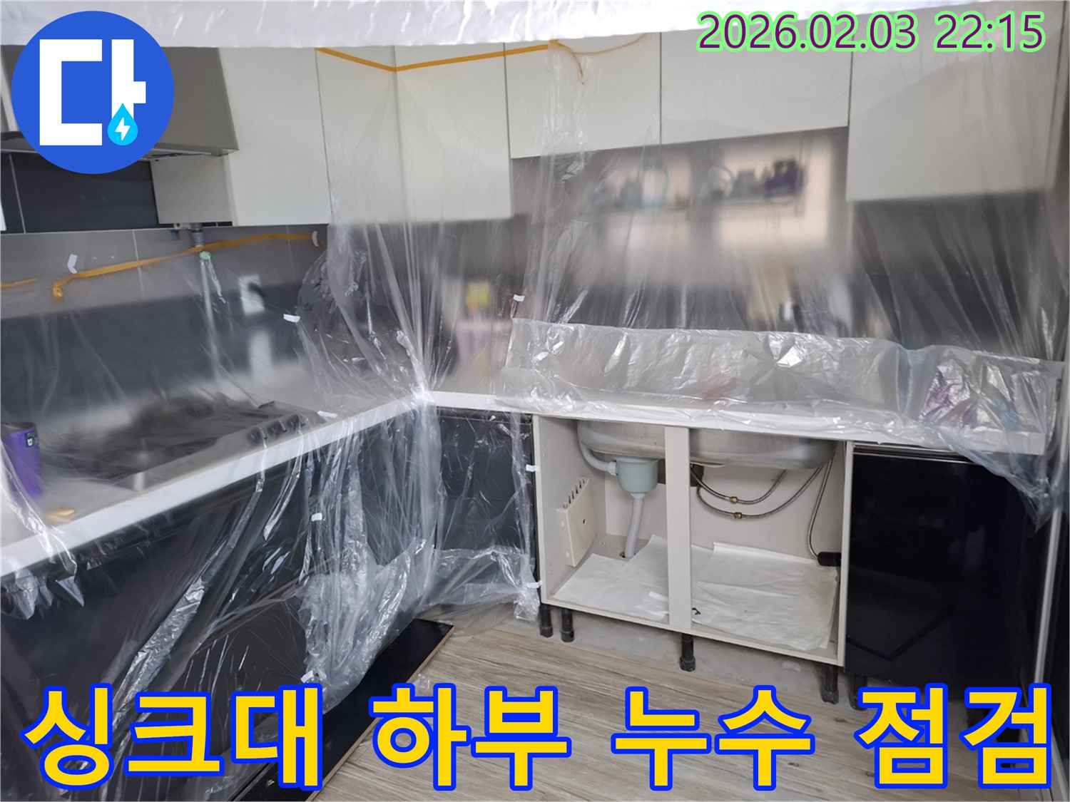 싱크대 하부 누수 점검 모습 - 누수 흔적을 꼼꼼히 확인하고 정확한 누수 원인을 파악하여 고객님께 상세히 설명드리고 있습니다.