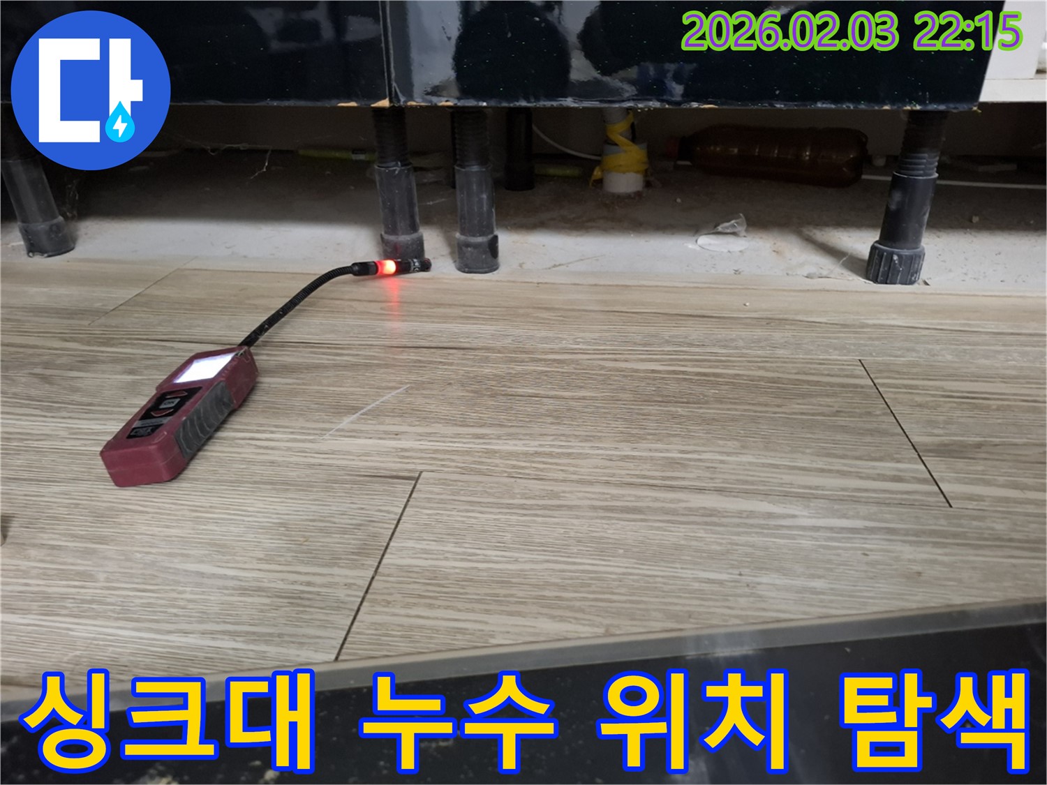 싱크대 하부에서 누수 탐지 장비로 누수 위치를 탐색하는 모습 - 좁은 틈새도 놓치지 않는 꼼꼼함!