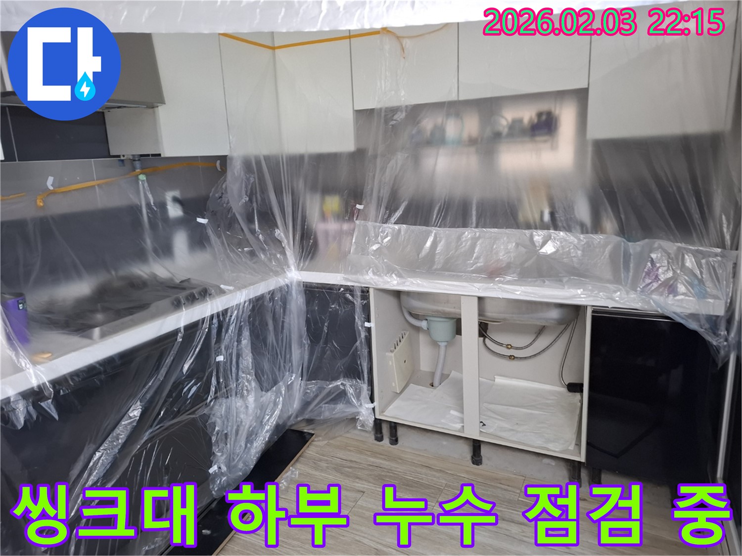 씽크대 하부 누수 점검 중 - 누수 지점을 찾기 위해 꼼꼼하게 살펴보고 있습니다. 숙련된 기술로 문제 해결!