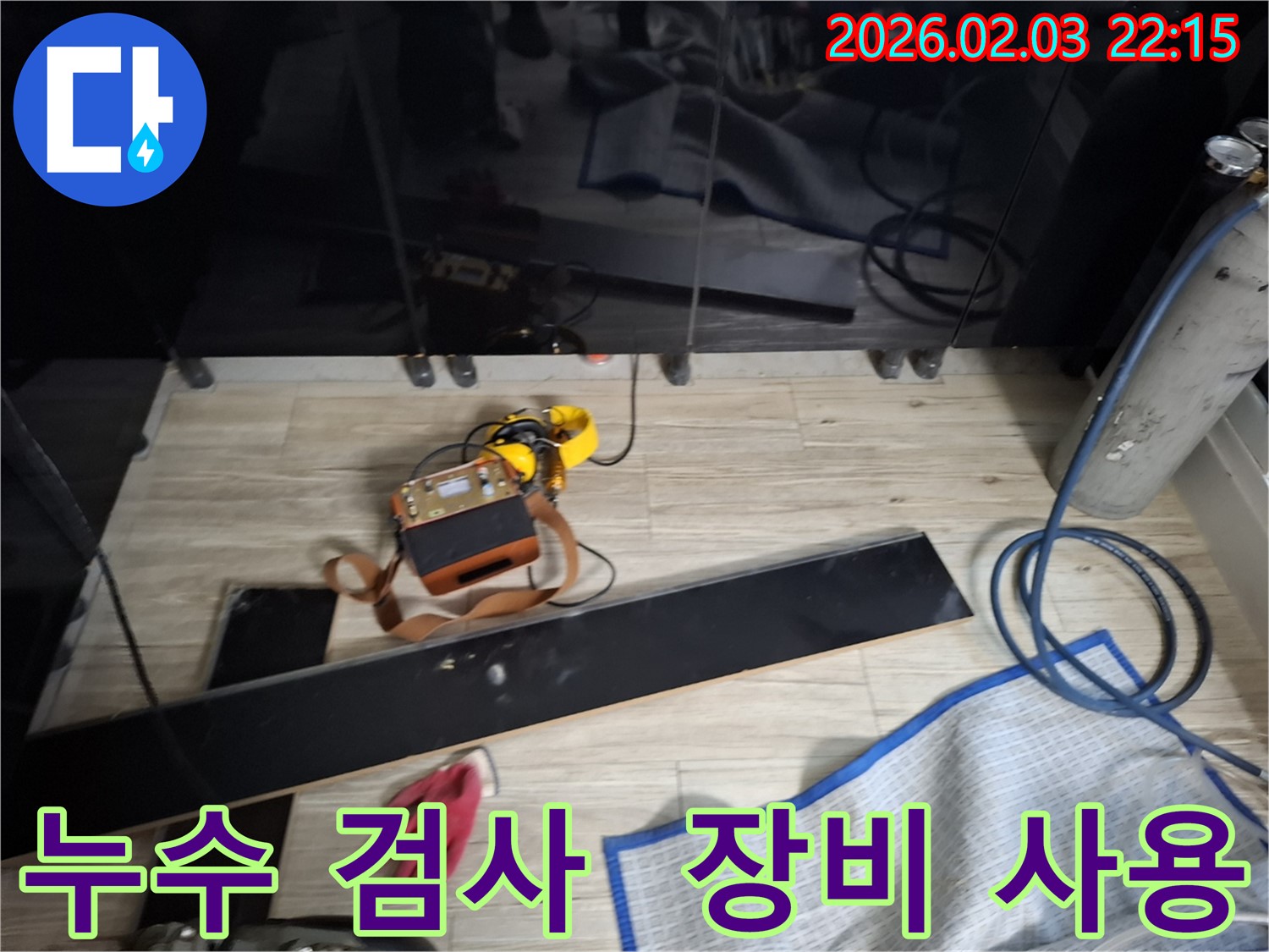 장판 밑 누수 검사 과정을 보여주는 사진 - 다양한 첨단 장비를 사용하여 꼼꼼하게 검사하는 모습입니다.