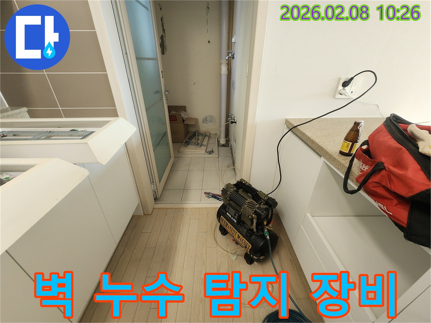 벽면 누수의 원인을 정확히 파악하기 위해-전문가가 공압 테스트 장비를 설치하고-배관 상태를 면밀히 확인하는 중입니다.