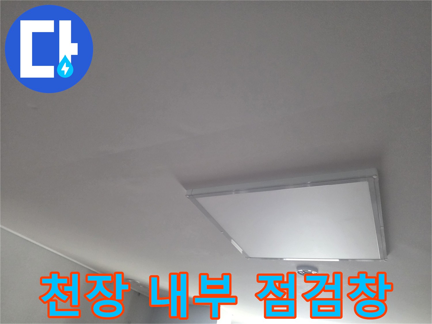 거실 천장에 설치된 사각형 모양의 점검구 사진입니다.