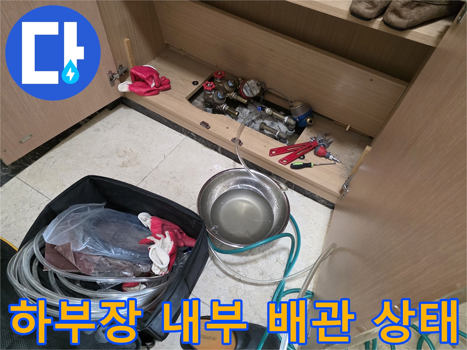 싱크대 밑 온수 밸브와 점검용 장비들
