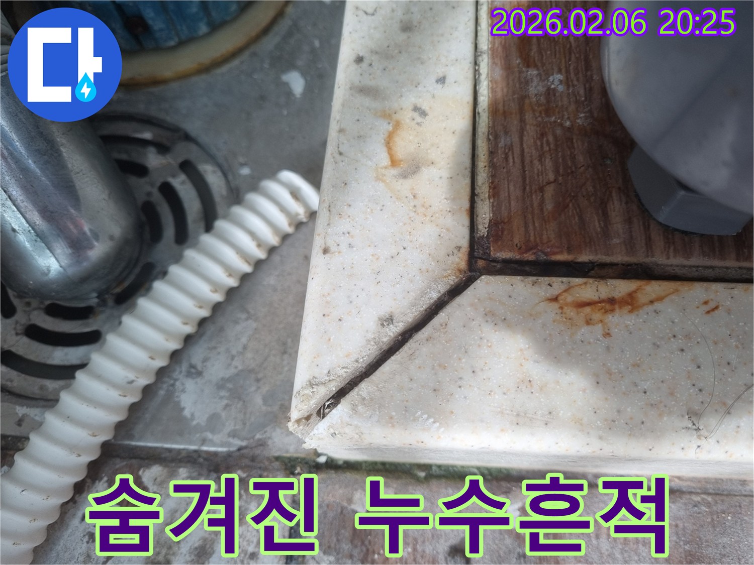 배수구 옆-오랜 시간 물이 새면서 생긴-녹슨 물자국과-오염된 표면을 보여주는-주택의 누수 현장입니다.